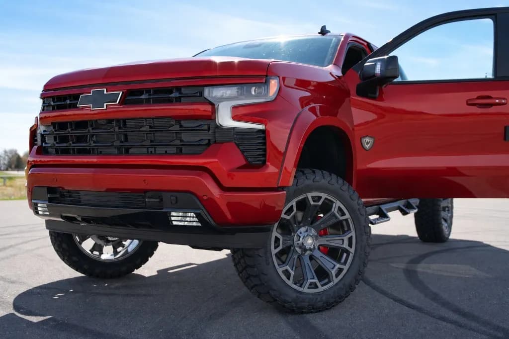 Close front view of the Radiant Red custom Chevy Silverado with the door open